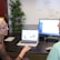 A woman mentoring a younger man in a professional setting.