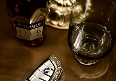 Bottle of remy martin, car key, and glass