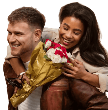 a man and woman smiling and holding flowers