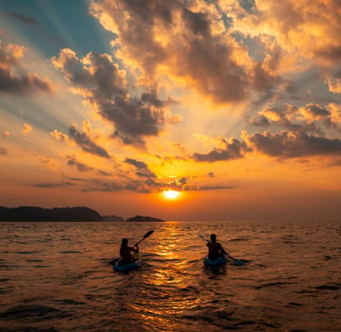 Sugar mommy and sugar baby are kayaking in the ocean at sunset